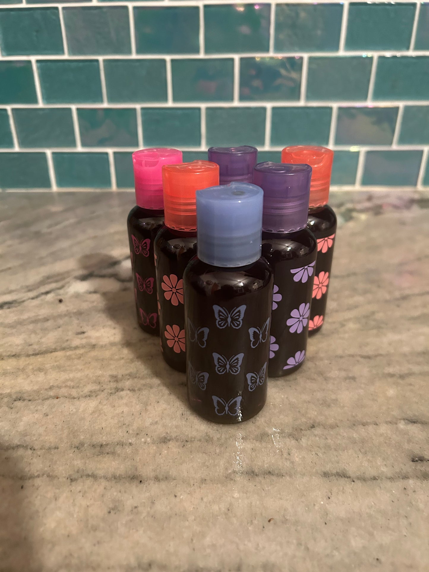 Set of small mosquito repellant bottles with colorful caps on a tiled floor