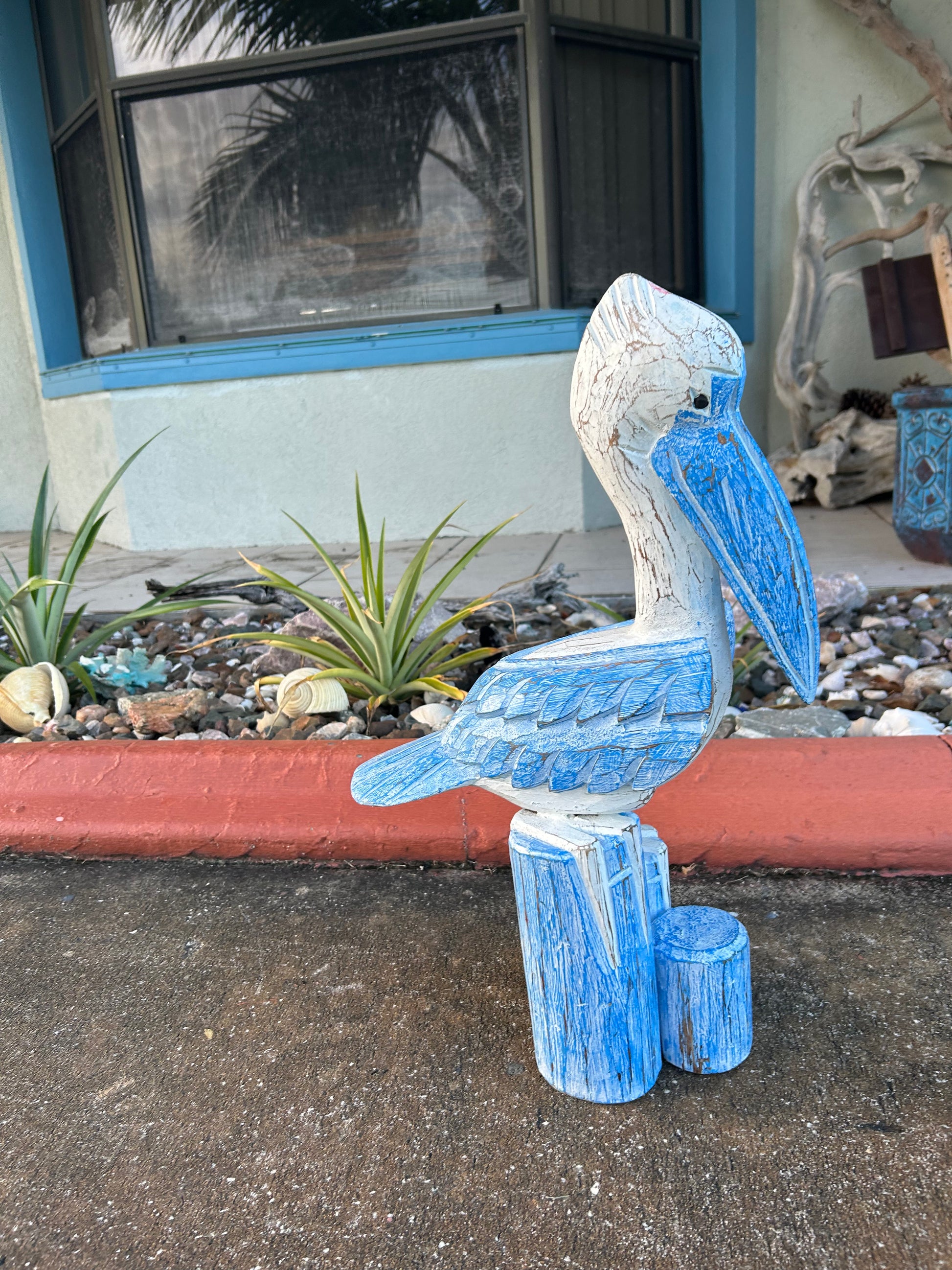 Decorative blue bird sculpture on a pole outside a building