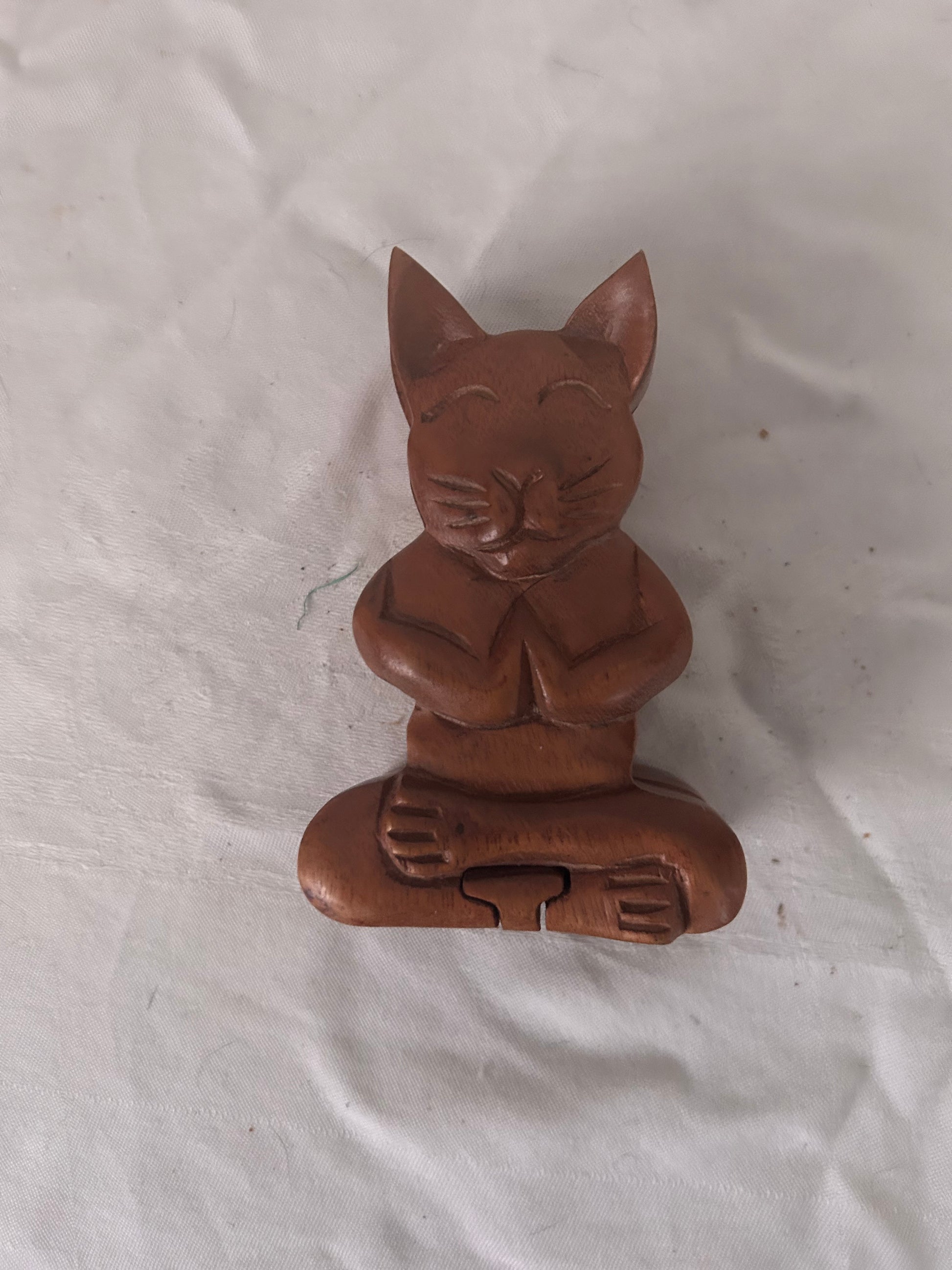 Brown cat-shaped object on a white fabric background