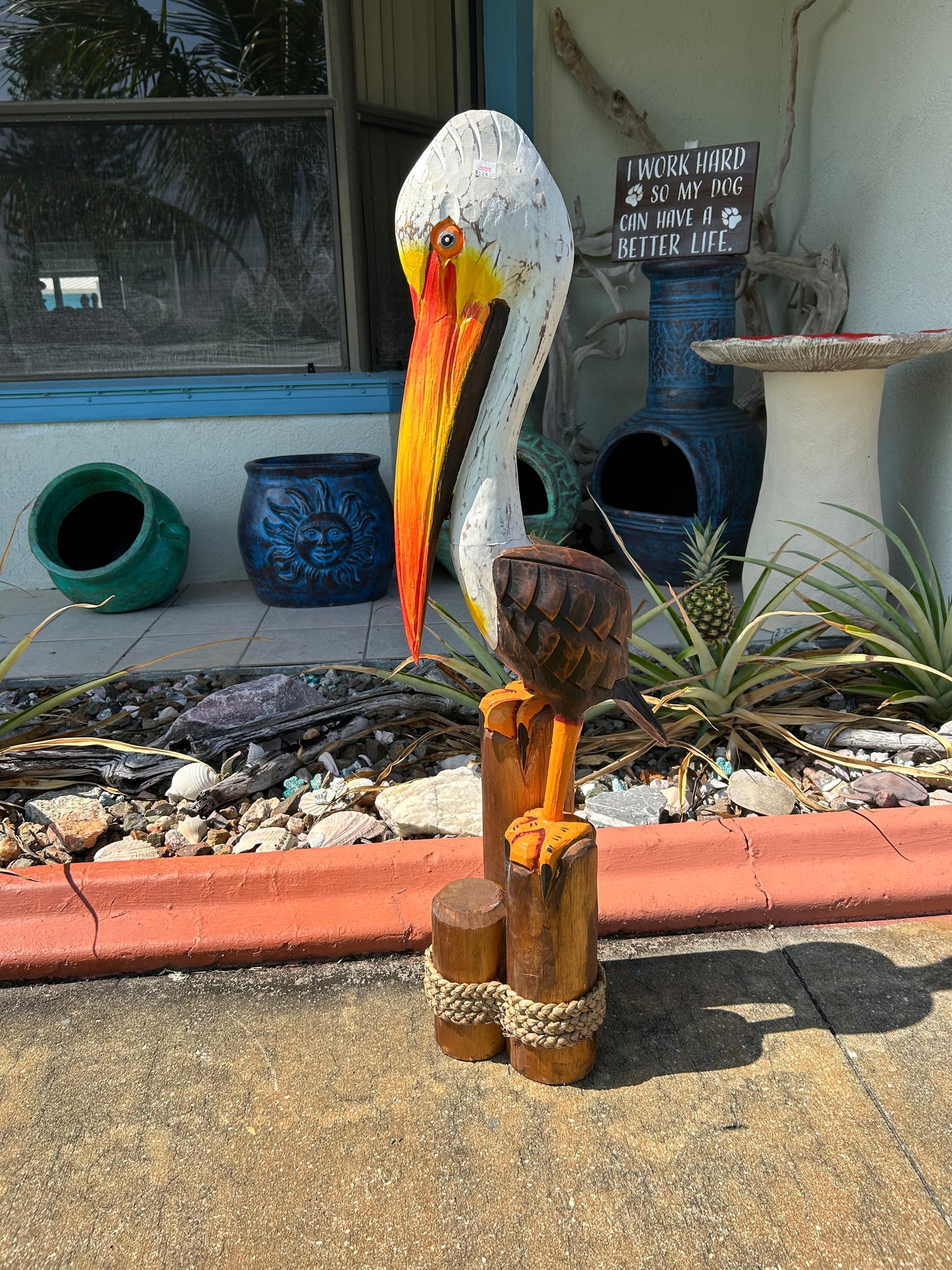 Decorative items including a wooden sculpture and colorful sticks on a stone surface.