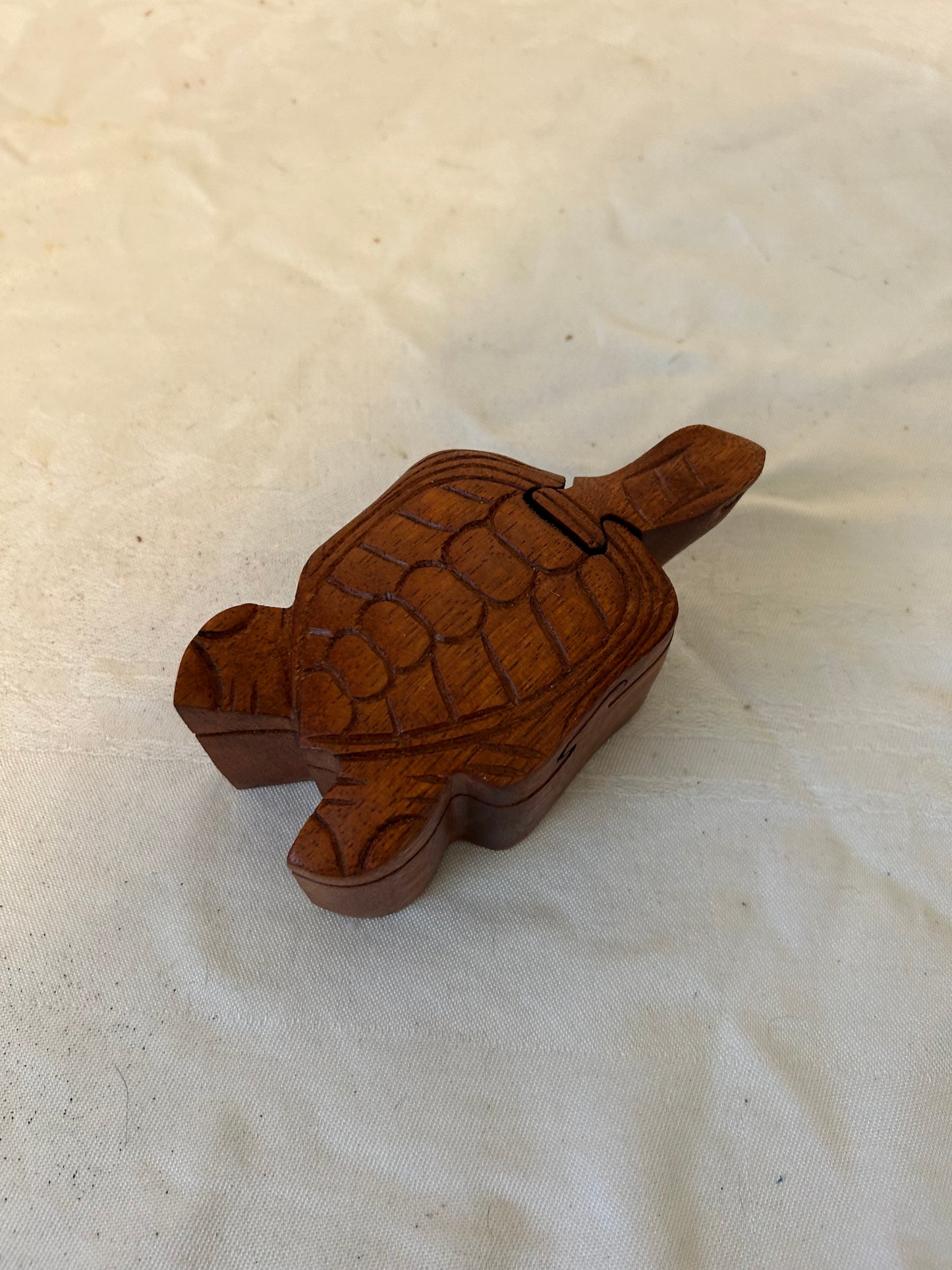 Wooden turtle figurine on a textured beige surface